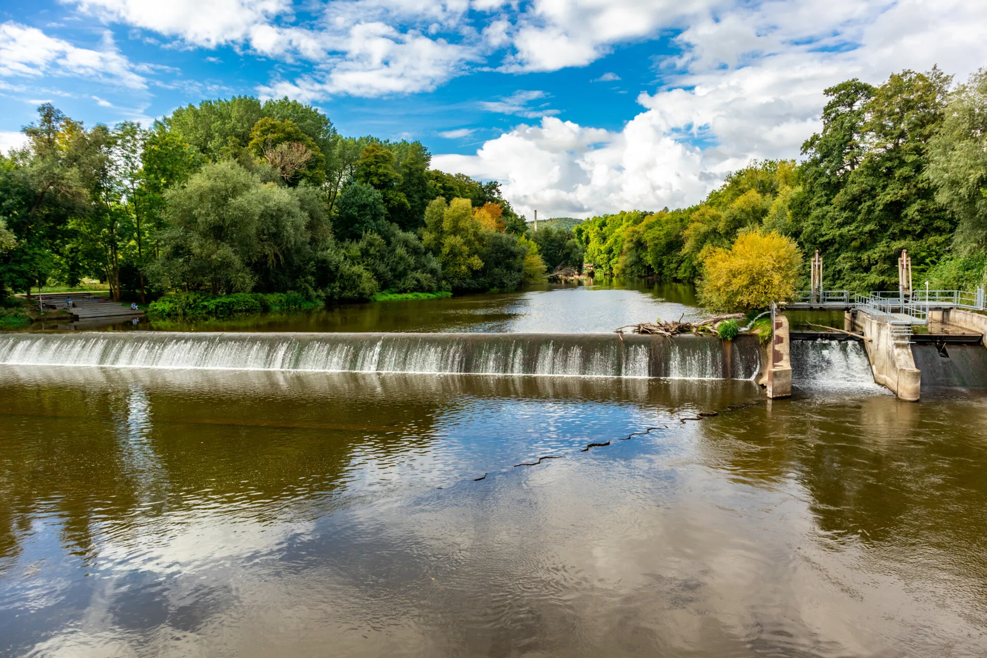 Naturschöne Flusslandschaft der Saale in Jena mit üppigem Grün und blauem Himmel